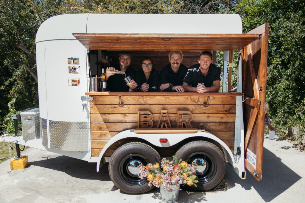 Group of bartenders smiling in bar cart