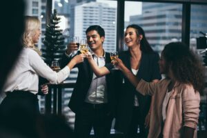 Group of people drinking together with a city in the background.